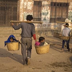 Kids taxi, two children carried in baskets on a pole