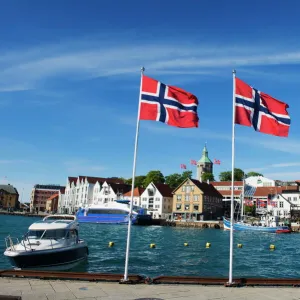 Norwegian flags and historic harbour warehouses, Stavanger, Norway, Scandinavia, Europe