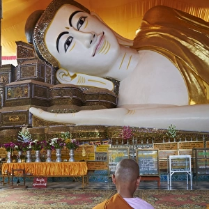 Nun in front of reclining Buddha statue, Shwethalyaung, Bago (Pegu), Myanmar (Burma), Asia