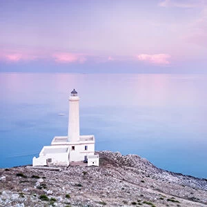 Pink sky on turquoise sea frames the lighthouse at Punta Palascia at sunset, Otranto