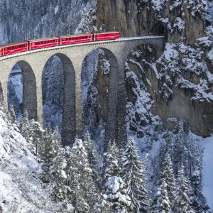 The red train of the Albula-Bernina Express Railway, UNESCO World Heritage on the Landwasser Viaduct, Switzerland, Europe