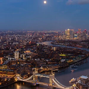 River Thames, Tower Bridge and Canary Wharf from above at dusk with moon, London, England
