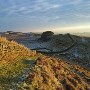 Sunrise and Hadrians Wall National Trail in winter, looking to Housesteads Fort, Hadrians Wall, UNESCO World Heritage Site, Northumberland, England, United Kingdom, Europe