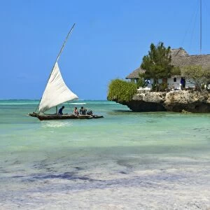 Tourist on a traditional Dhow boat, The Rock Restaurant, Bwejuu Beach, Zanzibar, Tanzania, Indian Ocean, East Africa, Africa