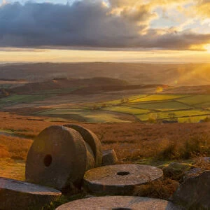 View of sunset and old millstones at Curbar Edge during autumn, Derbyshire, Peak