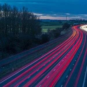 View of traffic trail lights on M1 motorway near Chesterfield, Derbyshire, England
