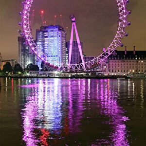 London Eye illuminated pink and the River Thames, London