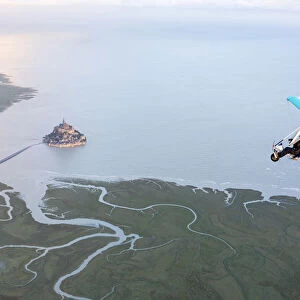 aerial view of Mont Saint Michel and Ultra light aircraft at high tide, Manche, France