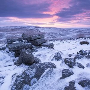 Beautiful sunrise over a frozen snow covered moorland, Belstone Tor, Dartmoor, Devon, England