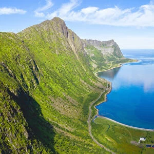 Blue sea of fjord framed by Husfjellet mountain in summer, aerial view, Steinfjord, Senja