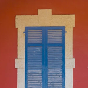 Blue wooden shutters and red wall in Larnaca, Cyprus