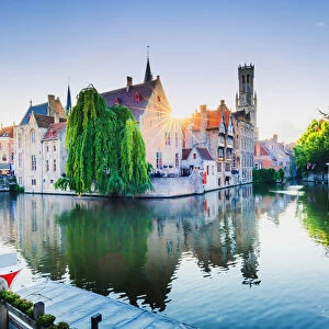 Bruges old town reflecting in the water canal at sunset, Belgium