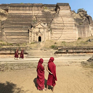 Buddhist monks walk past Pahtodawgyi pagoda, Mingun, Mandalay, Myanmar