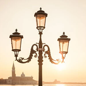 characteristic venetian lamp post in Riva degli Schiavoni, in the background the island