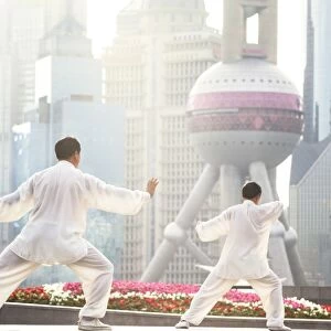 China, Shanghai. Chinese men practising Tai Chi on the Bund (MR)