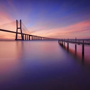 The colors of dawn on Vasco da Gama Bridge that spans the Tagus River in Parque das NaA'A§A'Aµes Lisbon Portugal Europe