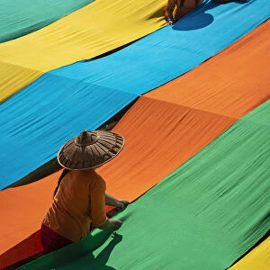 Elevated view of two women hanging long pieces of dyed fabric to dry, Lake Inle