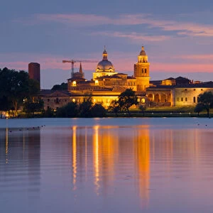 Mantova cityscape reflected in Mincio river at dusk. Mantova city, Mantova province