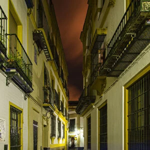 Night view of an empty street in Barrio Santa Cruz, Seville, Andalusia, Spain