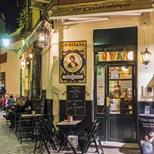 Night view of a tapas bar in Santa Cruz neighborhood, Seville, Andalusia, Spain