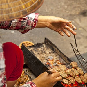 Preparing grilled pork as part of Bun Cha Street food, Old Quarter, Hanoi, Vietnam