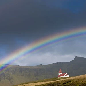 Rainbow over church, Vik, Iceland