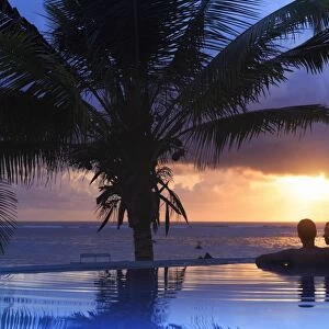 Tanzania. Zanzibar, Kigomani, Couple relaxing inside infinity pool overlooking the
