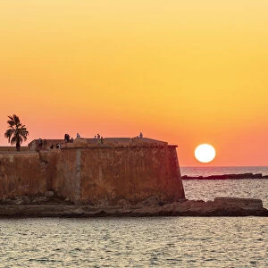Trapani, Sicily. Seascape of the Ligny tower with the sun setting in the sea