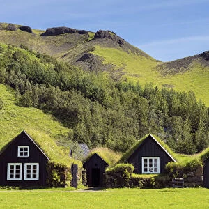 Turf roofed houses under mountain range at Skogar Museum, Skogar, Rangarping eystra, Southern Region, Iceland
