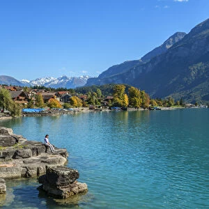 Woman sitting on the bank of Lake Brienz, Brienz, Berner Oberland, Switzerland