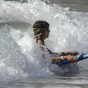 Girl boogie boarding on wave, West Dale beach, Pembrokeshire, Wales, UK, Europe