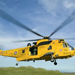 RAF Sea King Helicopter about to land on Crinkle Crags in the Lake district to evacuate an injured walker being treated by a mountain rescue team