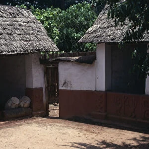 GHANA, Ashanti Traditional thatched house with intricate patterns on walls