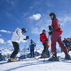 Group of skiers about to descend the mountain