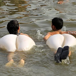Boys swim in a stream during a heatwave in Islamabad