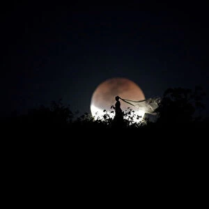 A bride poses for photo during a total lunar eclipse in Brasilia