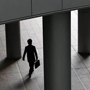 A businessman walks past pillars in Tokyo