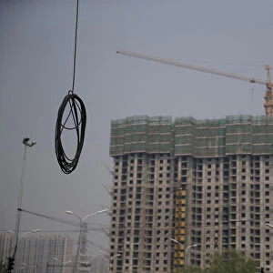 A cable is seen near residential buildings under construction in Beijing