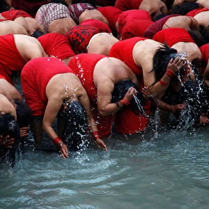 Devotees take a holy bath in the Bagmati River at Pashupatinath Temple during the