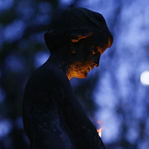 A grave monument is lit by candle light at the Powazki cemetery in Warsaw