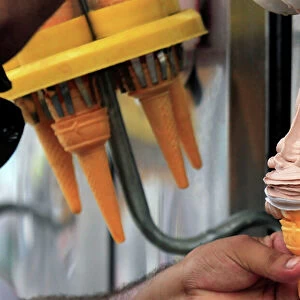 An ice cream vendor fills a cone with chocolate ice cream in Peshawar
