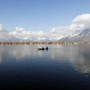 Print of a man rowing a small boat on Dal Lake Print of a man rowing a small boat on Dal Lake