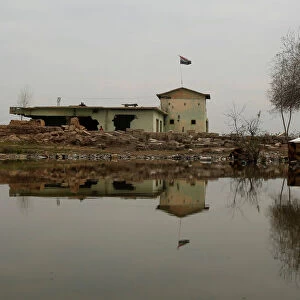 An Iraqi flag waves atop destroyed building after the area was retaken by Iraqi forces