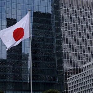 Japanese national flags flutter in front of buildings at Tokyos business district