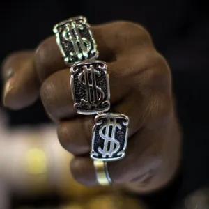 A man wears dollar sign rings in a jewellery shop in Manhattan in New York City