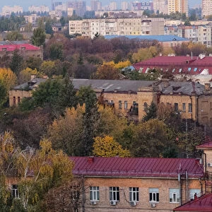 The morning sun shines on buildings and autumnal trees in an unusually hot autumn in Kiev