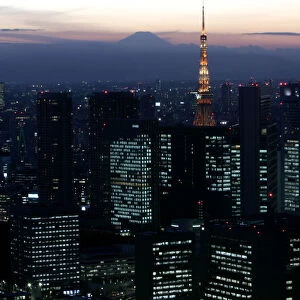 Night view shows Japans highest Mt. Fuji seen beyond Tokyo Tower and Shiodome district