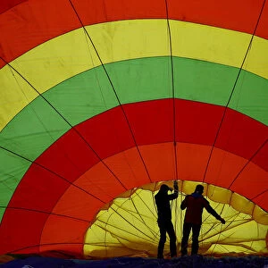 Participants prepare a balloon for inflation during the International Hot Air Balloon