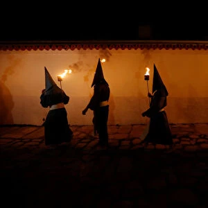 Penitents attend the Procession of the Torches during Holy Week in Goias Velho, west