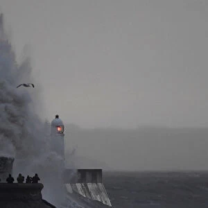People take images as large waves and high winds associated with Storm Ffion hit the